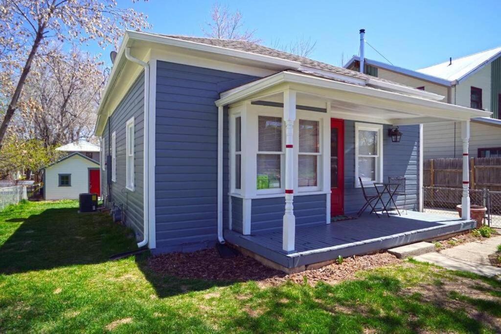 a tiny house with a porch and a red door at Retro bungalow workspace fast WiFi in Louisville