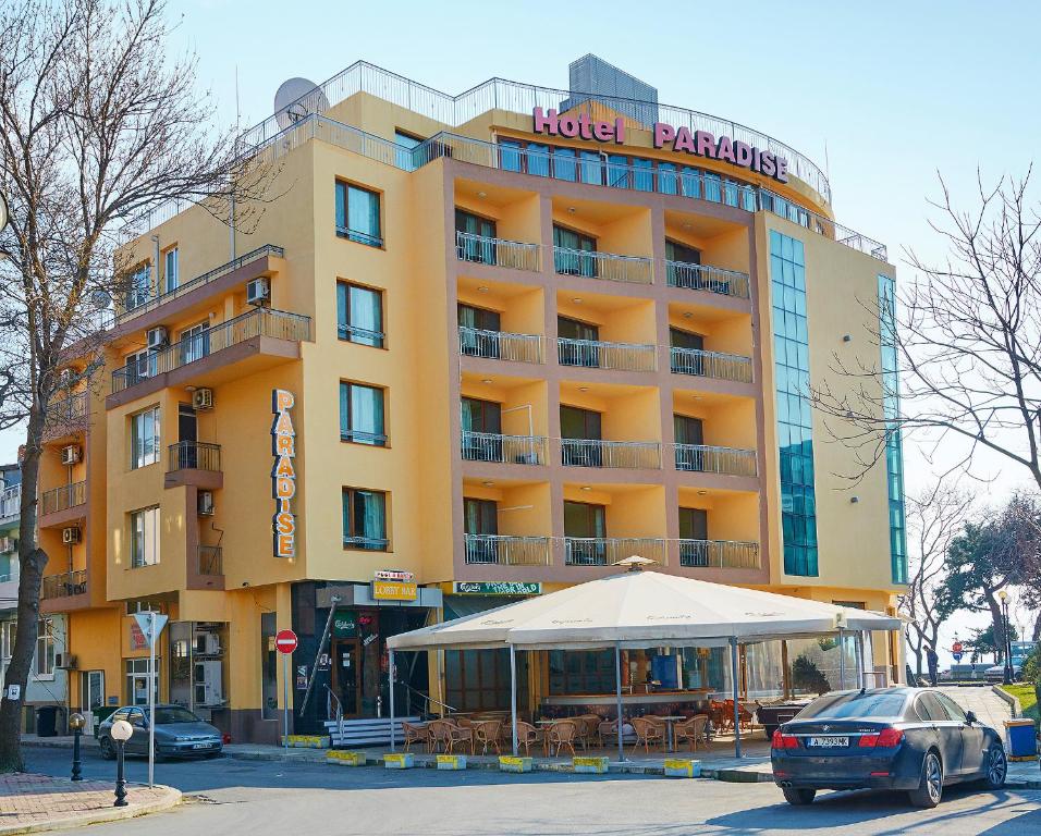 a hotel building with an umbrella in front of it at Paradise Hotel & Relax Center in Pomorie