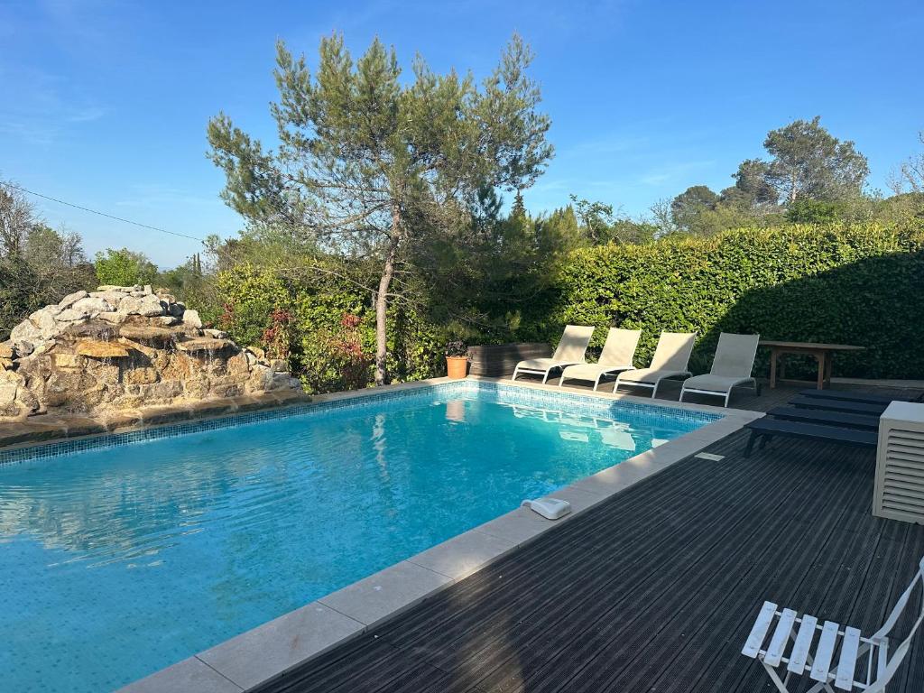 a swimming pool with two chairs and a table at Central Valbonne Villa in Valbonne