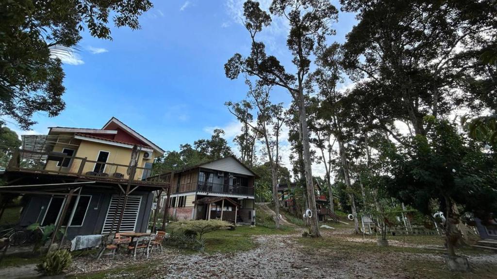 una casa en medio de un patio con árboles en Resort D Rumah Bonda River View Kuala Kangsar en Kampong Senawar