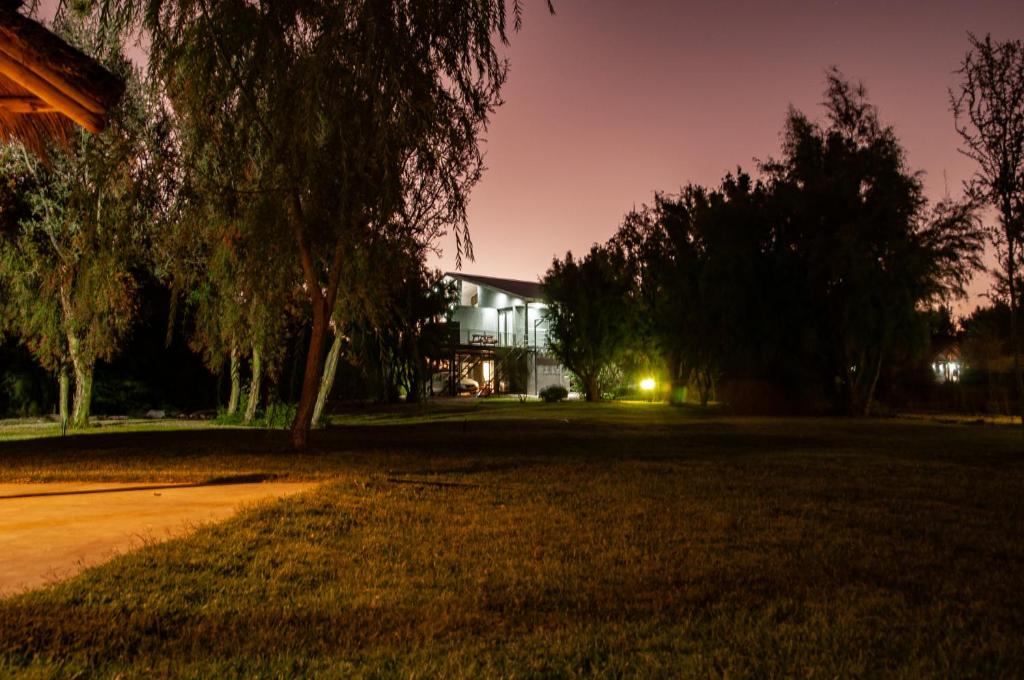a house at night with a tree in the foreground at Jardines del Atuel in Valle Grande