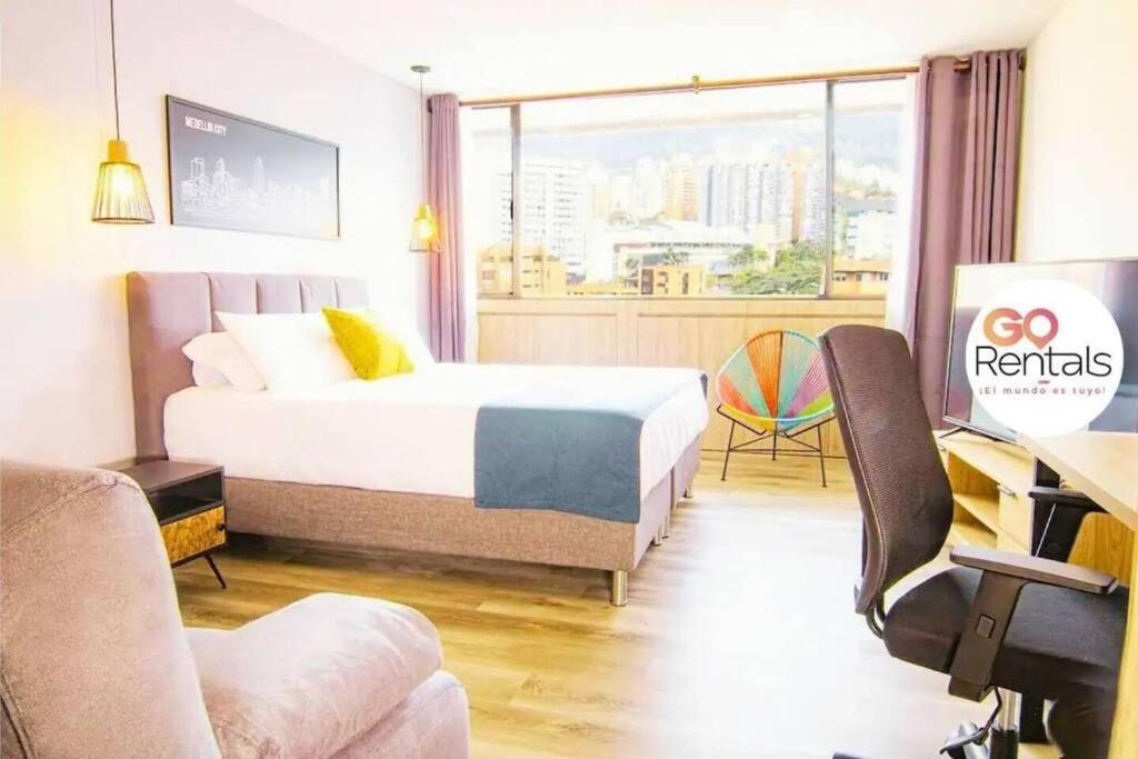 een hotelkamer met een bed, een bureau en een raam bij Bright Studio Topfloor A/C, Poblado Coworking1412 in Medellín