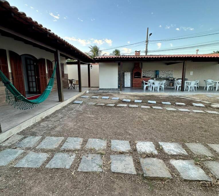 un patio de una casa con mesas y sillas en Casa Completa, muito bem localizada !, en Búzios