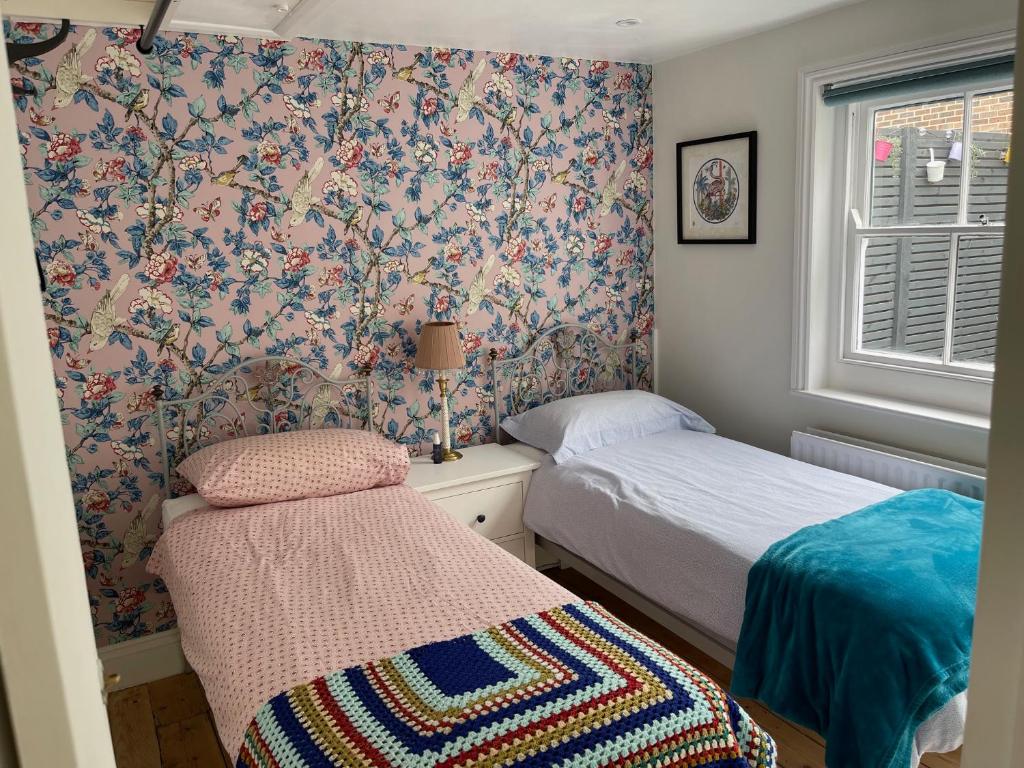 a small bedroom with two beds and a window at North Laine Sunny Cottage in Brighton & Hove