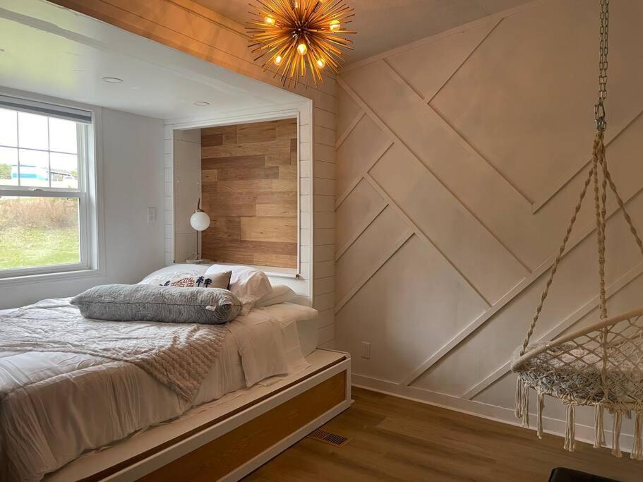 1 dormitorio con 1 cama grande y pared de madera en The Barn at Griffith Road, en Logan