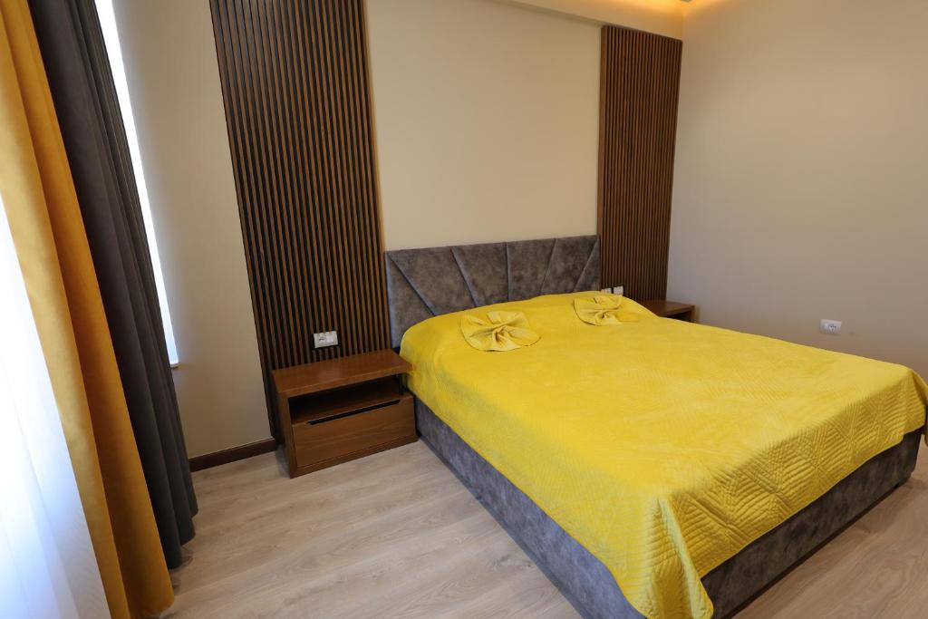 sypialnia z łóżkiem z żółtym kocem w obiekcie Rezidenca Arlington w mieście Berat