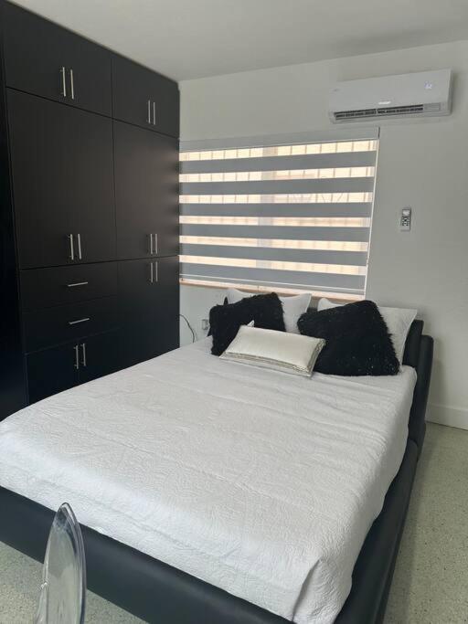 Hotel VillaClara Studio-Little Havana, a bedroom with a large bed with black cabinets at VillaClara Studio-Little Havana in Miami