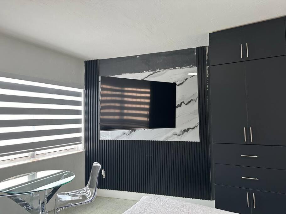 a room with a table and a chair and a mirror at VillaClara Studio-Little Havana in Miami