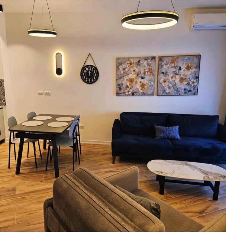 a living room with a blue couch and a table at Klaudia Apartments in Himare