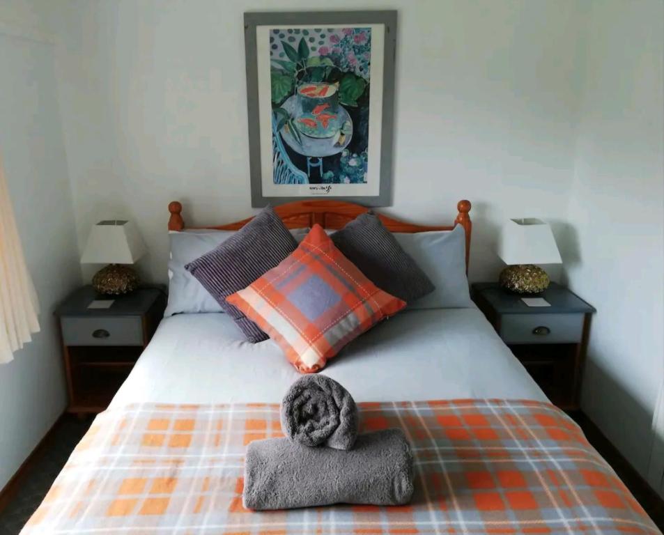 a bedroom with a bed with a hat on it at Cosy Cottage in Saint Columb Major