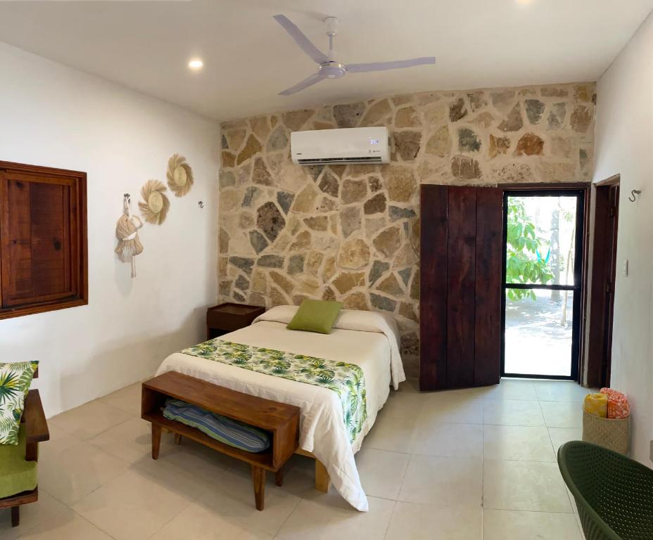 テルチャク・プエルトにあるCasa ALBU Telchac centroのベッドと石の壁のある寝室