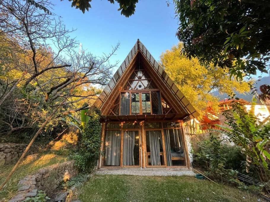 uma pequena casa com um telhado de gambrel em Beautiful Cabin at Gaia Temple em Tzununá