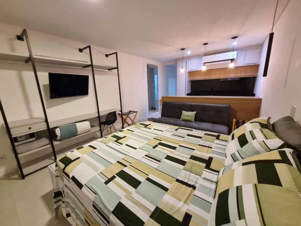 a bedroom with a large bed and a couch at Flat Home Business 303 Centro de Pomerode in Pomerode