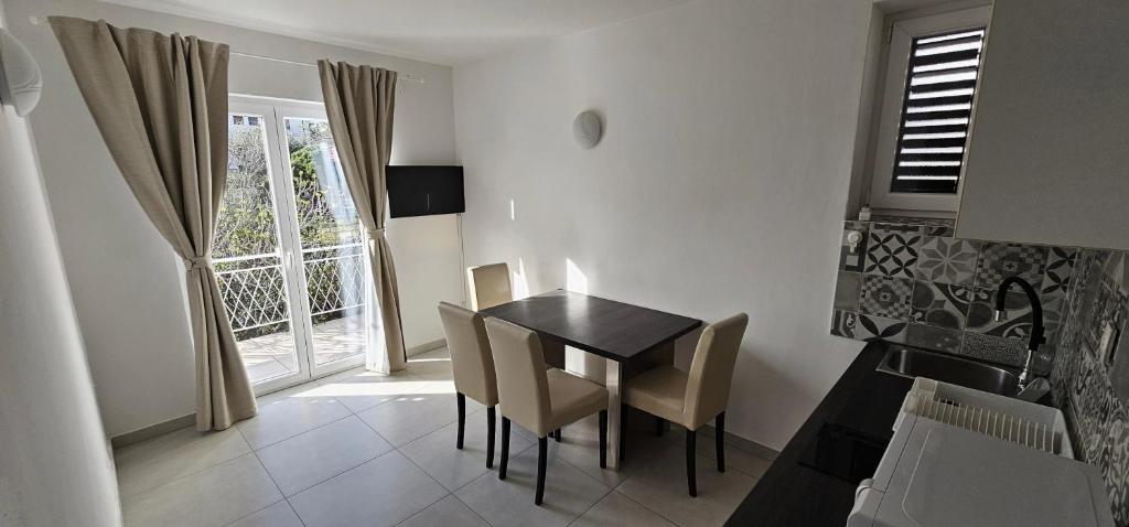 jadalnia ze stołem i krzesłami oraz oknem w obiekcie Apartment Buco w mieście Starigrad-Paklenica