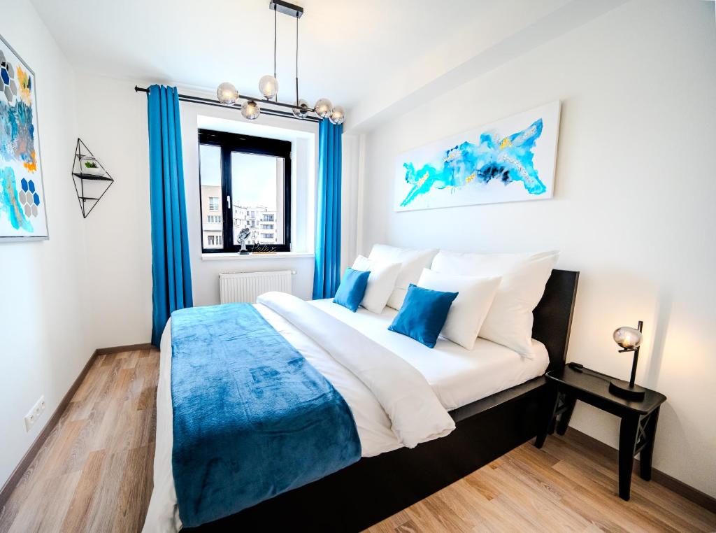 een slaapkamer met een groot bed met blauwe accenten bij D&L Luxury Apartment in Old Town, Bratislava in Bratislava