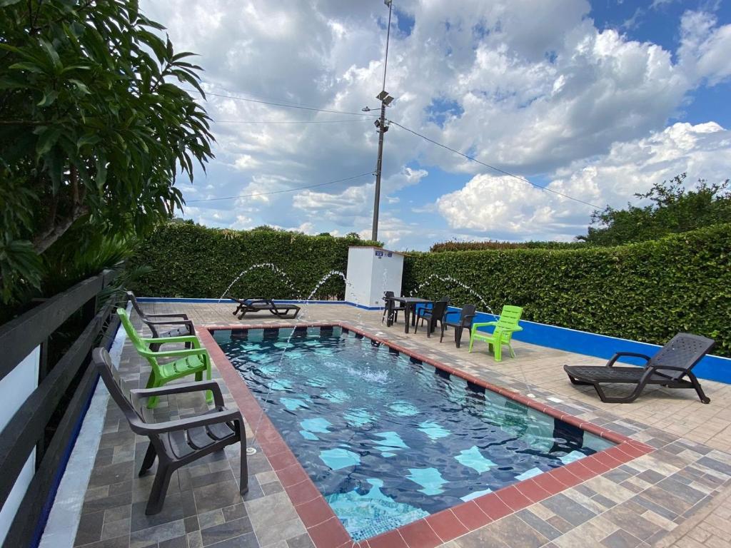 a swimming pool with chairs and a table at ECORAUDAL posada campestre in San José del Guaviare