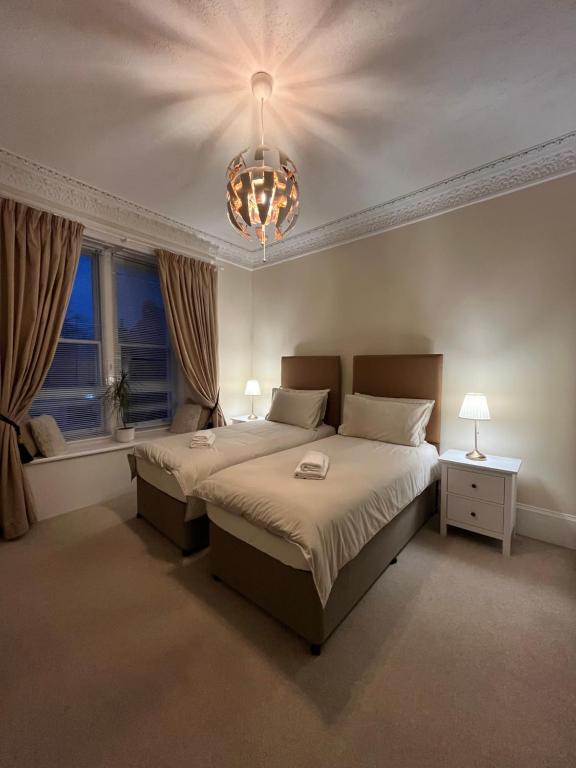 a bedroom with a large bed and a chandelier at Aaaa do not use in Stirling