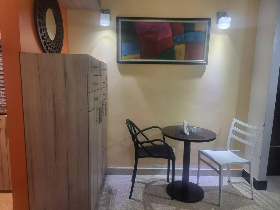 a room with a table and two chairs and a cabinet at R.503 Lindo y funcional apartaestudio en el centro in Panama City