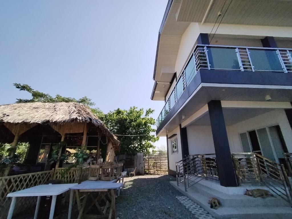 a building with a thatch roof and tables next to it at TERESITA RESIDENCE in Manaoag