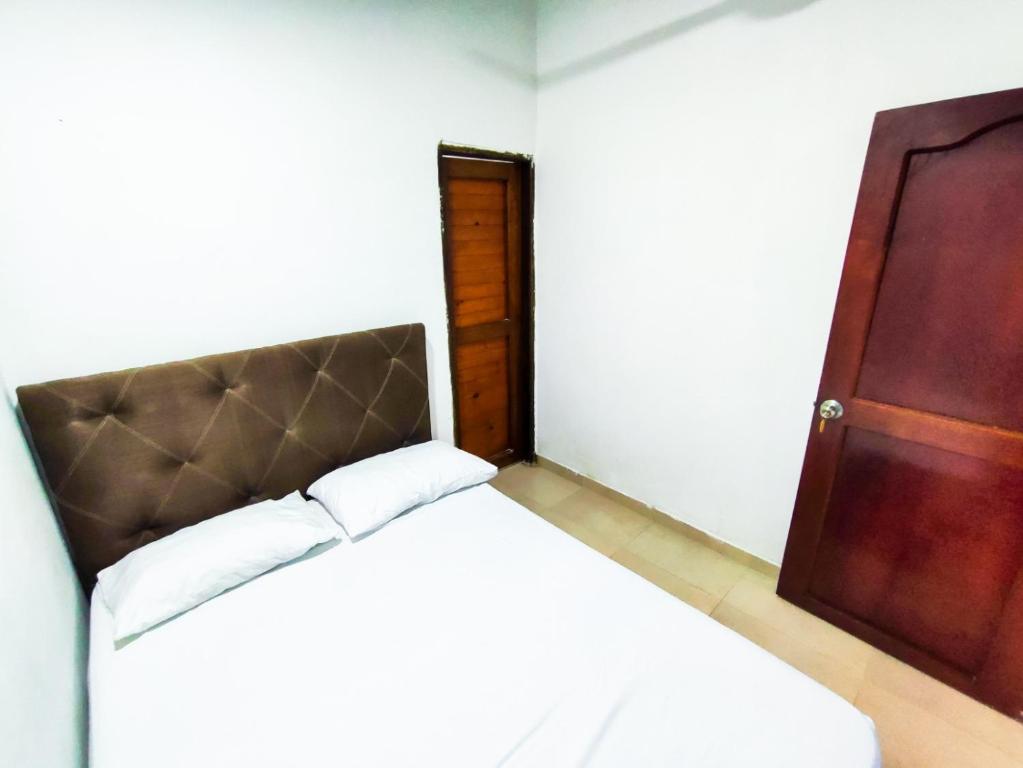 um quarto com uma cama e uma porta de madeira em Hotel Palmahia Moñitos em Moñitos