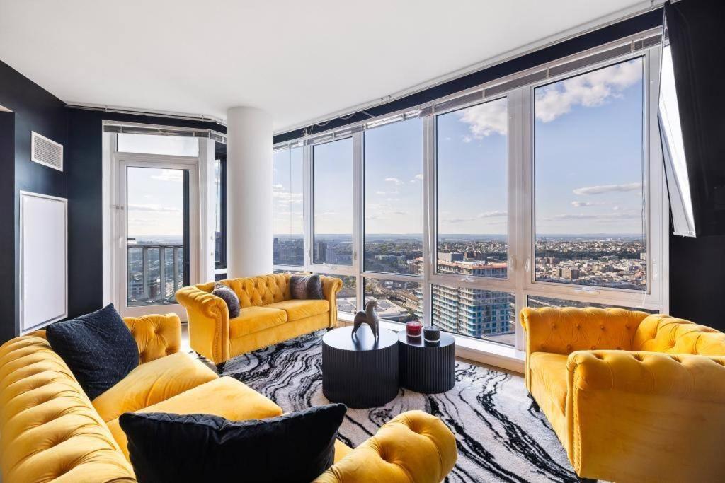 una sala de estar con sofás amarillos y ventanas grandes. en Modern 3 BR 3.5 BA Breathtaking en Jersey City
