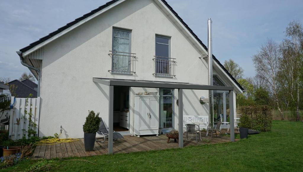 een wit huis met een deur open op een terras bij Fewo Aron in Tönning