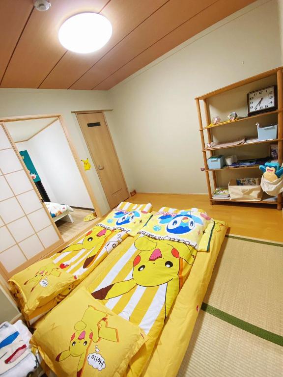 a bedroom with a bed with hello kitty sheets at Pokémon Sleep 宝可梦的家 in Osaka