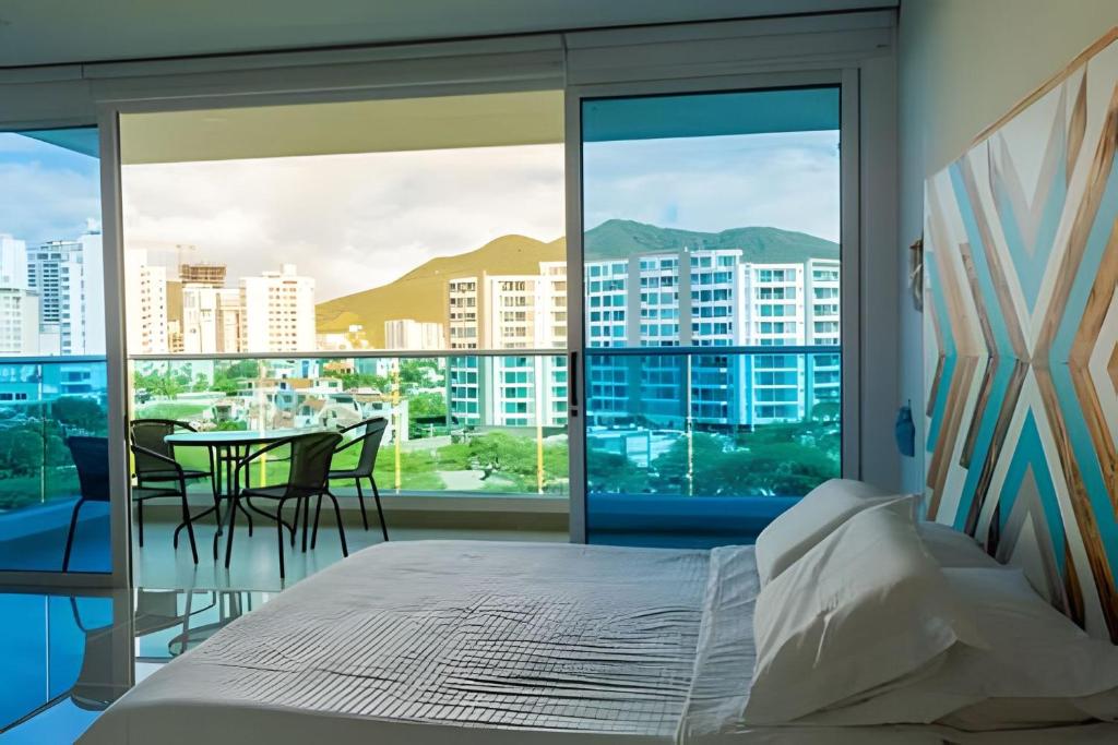 1 dormitorio con 1 cama y balcón con mesa en Reserva del Mar - Club de Playa, en Santa Marta