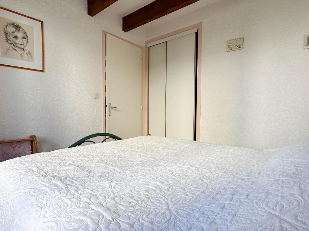 - une chambre avec un lit blanc et une porte dans l'établissement Maison en Pinède Proche Mer et Commerces - 5 pers, Terrasse, Jardin, Parking, WiFi - FR-1-705-29, à La Palmyre