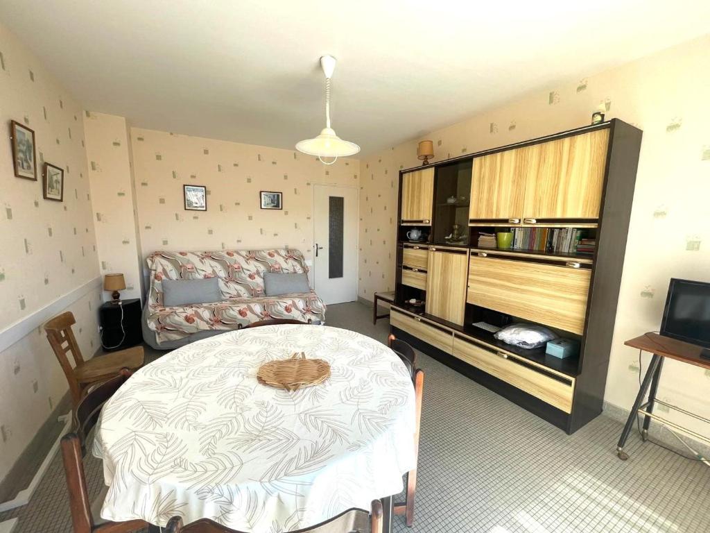 une chambre avec un lit, une table et une télévision dans l'établissement Appartement calme à Saint-Jean-de-Monts, 150m plage, balcon exposé Sud/Ouest, parking privé - FR-1-323-305, à Saint-Jean-de-Monts