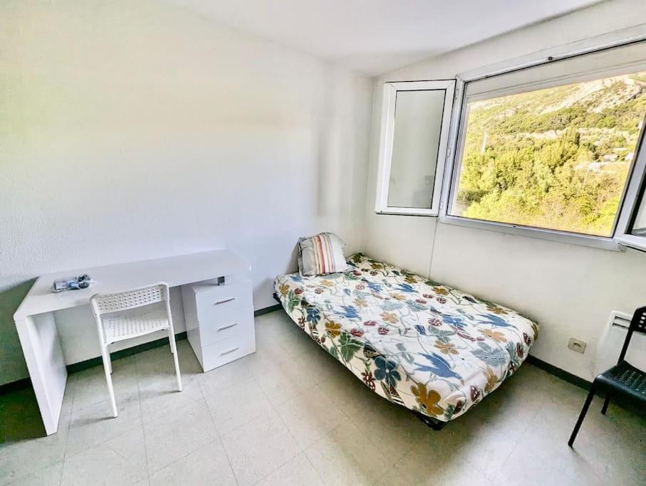 a bedroom with a desk and a bed and a window at Pratique, Proche Gare & Petit Prix avec Parking in Grenoble