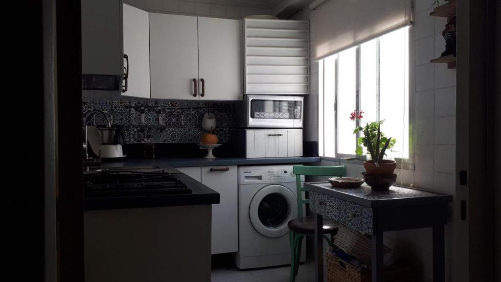 cocina con lavadora y ventana en Habitación en Sevilla dias/semana, en Camas