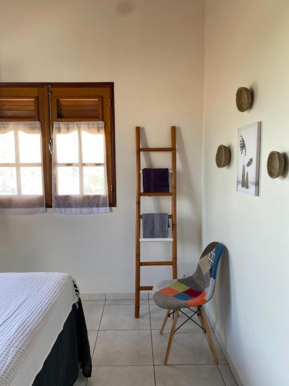 ein Schlafzimmer mit einem Bett und einem Stuhl in einem Zimmer in der Unterkunft KARIFUNA-II in Baie Mahault