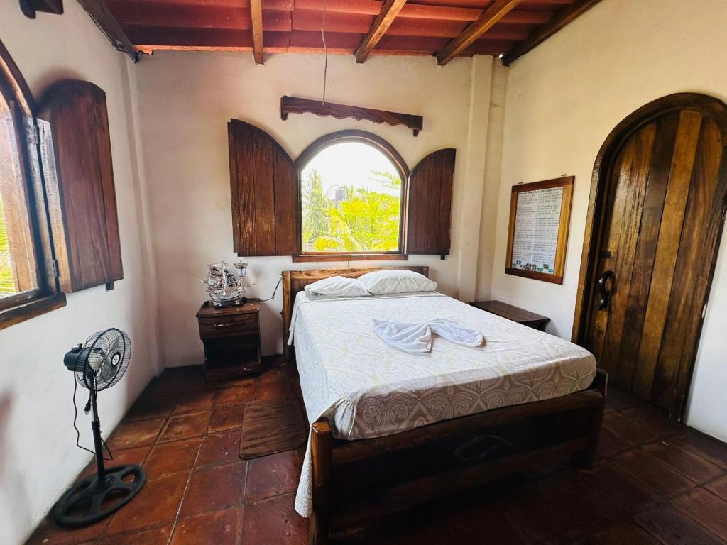 een slaapkamer met een bed en een raam bij Casa Villa Pesca in Monterrico