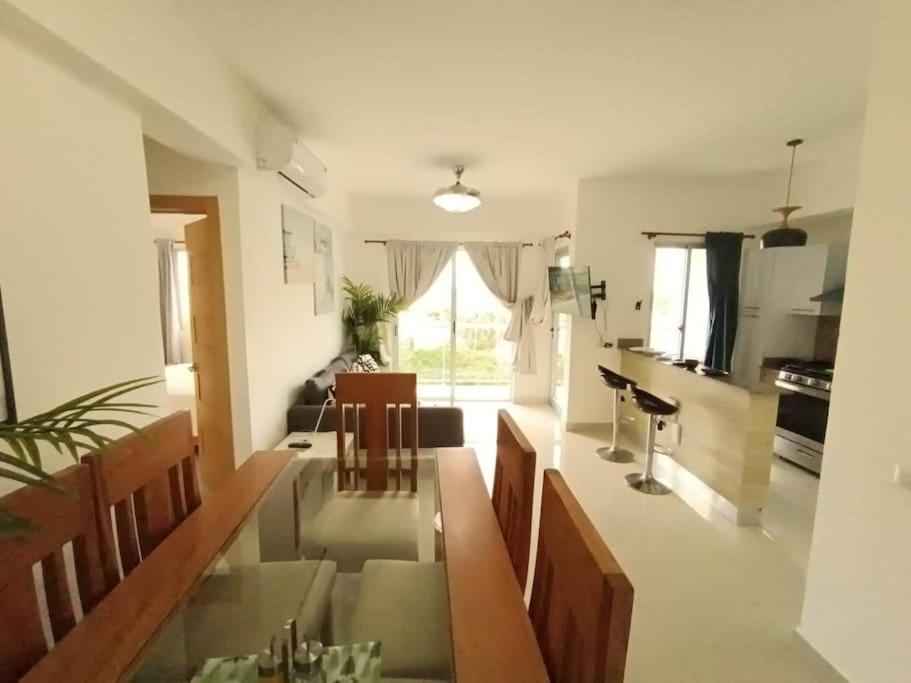 a kitchen and living room with a table and chairs at Apartamento Marla Comodo y cerca del aeropuerto in Santo Domingo