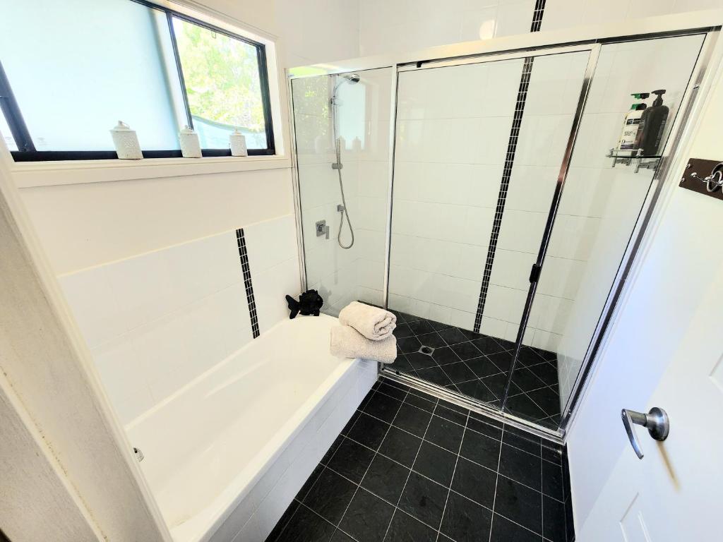 a bathroom with a tub and a glass shower at Island Room in Horseshoe Bay on Magnetic Island in Horseshoe Bay