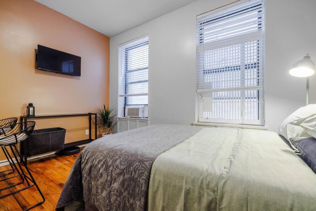 Schlafzimmer mit einem Bett und einem Flachbild-TV in der Unterkunft Park Side Living, Get Cozy in New York