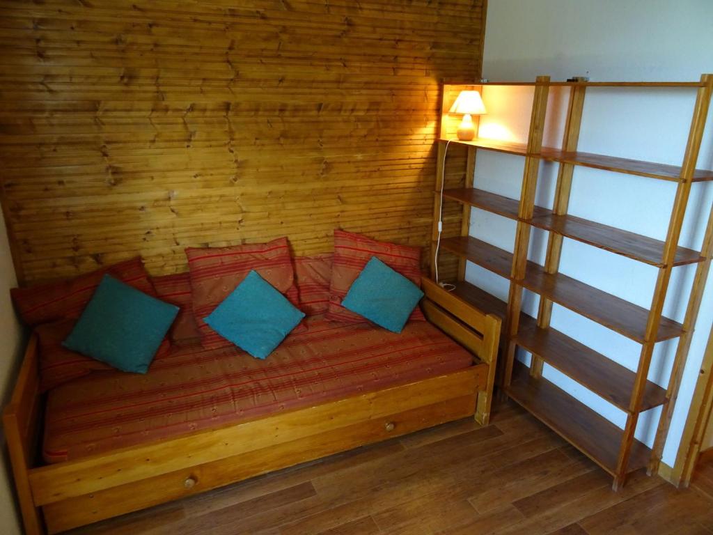 - un lit en bois avec des oreillers bleus dans l'établissement Studio cabine à Vallandry, 22m², 4 pers, proche pistes et commerces - FR-1-411-940, à Landry