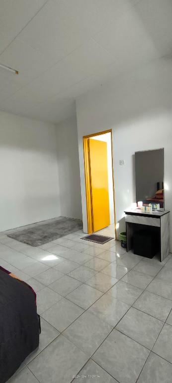 a room with a yellow door and a tile floor at Homestay Atikah Bahau in Bahau
