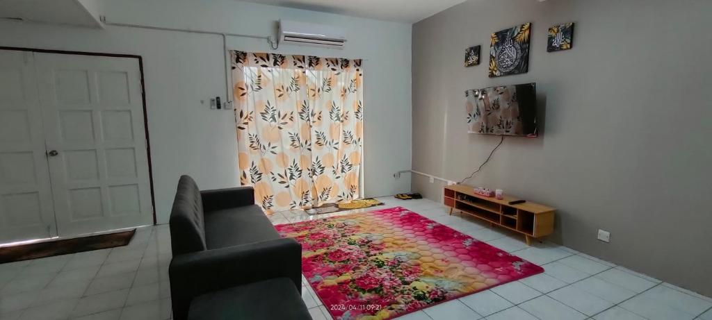 uma sala de estar com um sofá e um tapete em Homestay Atikah Bahau em Bahau