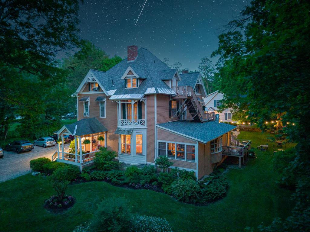 - une vue aérienne sur une grande maison la nuit dans l'établissement Brook Farm Inn, à Lenox