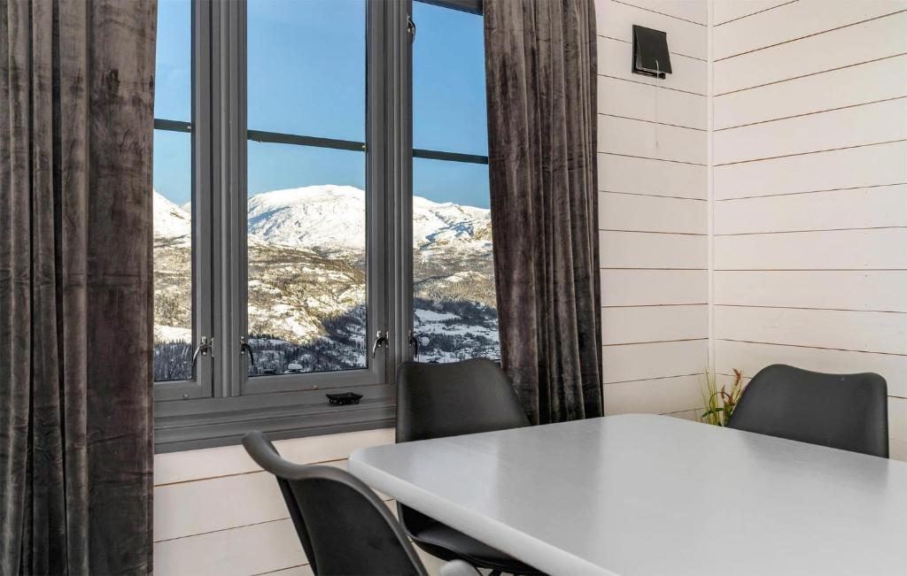 海姆瑟達爾的住宿－Nice Apartment In Hemsedal With House A Mountain View，窗户客房内的桌椅