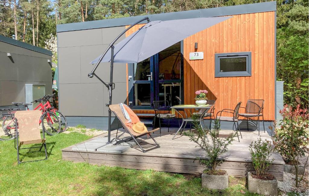 a house with a table and chairs and an umbrella at Tiny Haus 73 Am Brombachsee in Pleinfeld