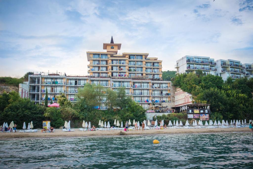 - un grand bâtiment sur la plage avec une plage dotée de parasols dans l'établissement Tiva del Mar Beach Hotel, à Sveti Vlas