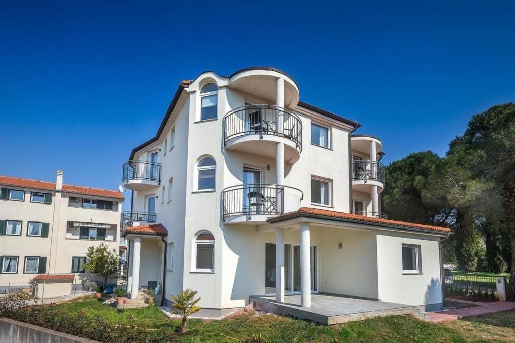 ein großes weißes Gebäude mit Balkonen darauf in der Unterkunft Ferienwohnung für 4 Personen ca 40 m in Medulin, Istrien Südküste von Istrien - b52058 in Medulin