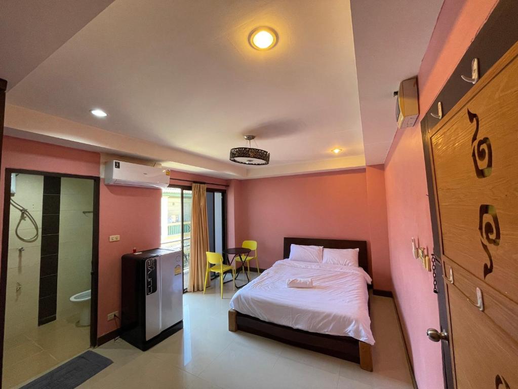 een slaapkamer met een bed en een badkamer bij ธารา นาคา อพาสเม้นต์ in Ban Rangeng