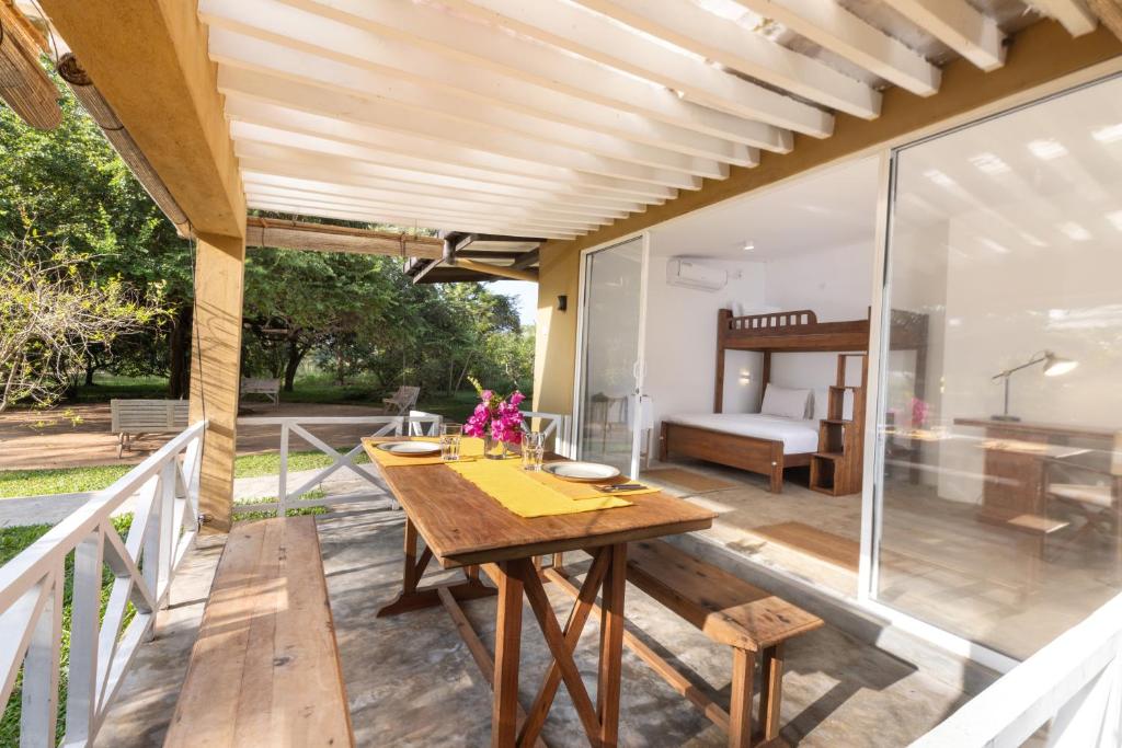 a patio with a wooden table and a bedroom at Jasper Cub in Wilpattu
