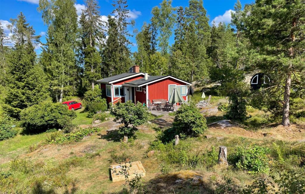 una casa roja en una colina con árboles en Lovely Home In Ljuster With Wifi, en Norra Ljustero