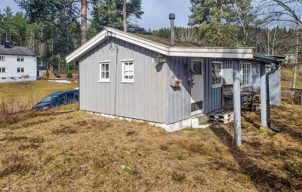 a small blue shed sitting on top of a field at 3 Bedroom Beautiful Home In Rmskog in Rømskog