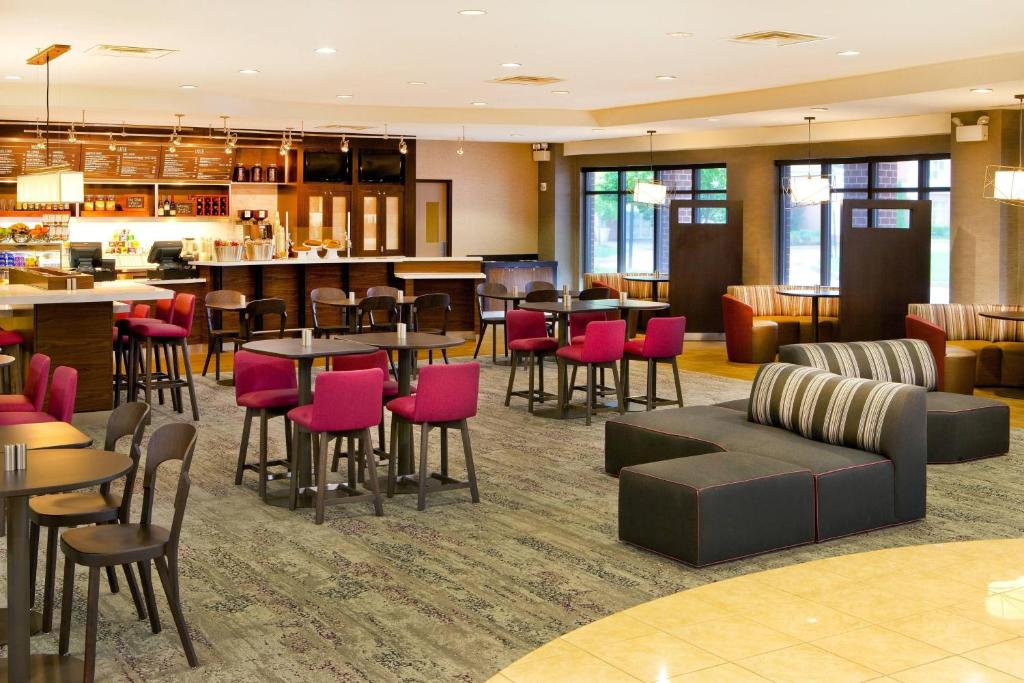 a hotel lobby with tables and chairs and a bar at Courtyard by Marriott Gettysburg in Gettysburg